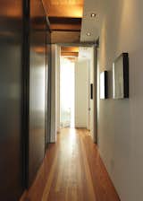 A long hallway from the living room separates the public and private sections of the home and extends the distance between the living quarters and work spaces.