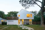A revamp of this small suburban Massachusetts home doubled its size while giving the yard, the neighbors, and the planet a little breathing room. Photo by: Chang Kyun Kim  Photo 1 of 5 in Asymmetrical Homes by Luke Hopping from Striking Modern White Facades Part Two 