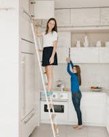 Schaffer’s two teenage daughters tend to gather in the kitchen, particularly on the custom-made ladder fabricated by Index-d. Joking about having her immediate family as clients, the architect says, “I was faced with a much more discerning and critical audience. To lure my kids away from Instagram and Snapchat, the house had to have form and function meeting fun.” To incorporate every family member into the planning of the space, Schaffer allotted niches for dish storage (like the girls’ set of Pantone mugs) and a pull-out pantry at eye-level.  Photo 11 of 12 in COCINAS by Laura Aristizábal Franco from An Arctic White Kitchen Renovation in Connecticut