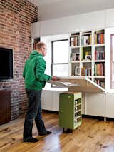 When it’s time to eat or do homework, the adults lower the tabletop, revealing a dozen book cubbies.  Photo 6 of 7 in Green Renovations by Erika Heet from A Storage-Smart Renovation in New York City