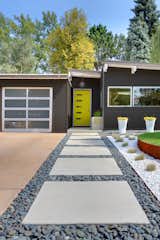 Generous concrete pavers lead to the entrance. The home's angles are typical of the midcentury homes in the neighborhood.