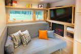 A small fireplace complements the coziness of the living area. Built-in shelving helps cut down on clutter.  Photo 5 of 7 in This Travel-Ready Trailer May Look Small, But It Can Sleep Six by Luke Hopping
