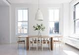 Resolution 4: Architecture designed a Union Square duplex for an expat couple with two children. Hans Wegner Wishbone chairs are arranged around a wooden dining table in one sunny corner of the apartment.  Photo 1 of 1 in Call for Dwell New York Home Tour Submissions