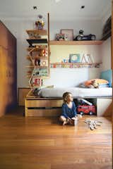 Kids, Bedroom, Shelves, Bed, Storage, Pre-Teen, Medium Hardwood, and Boy Tom’s compact bedroom feels much larger thanks to interlocking shelves and storage. The plywood bed and surrounding shelving were custom-built by Wilkin and a hired carpenter.  Kids Storage Bed Shelves Photos from Almost Perfect
