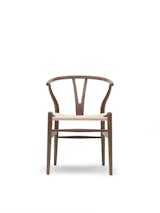 The Wishbone Chair (1949), also known as the Y Chair, marries a hand-woven seat and steam-bent frame. The chair, an undisputed modern icon, has been in continuous production since its introduction in 1950. Inspired by portraits of Danish merchants sitting in Ming chairs, this was the culmination of a series of chairs created in the '40s.