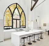This home in a former Chicago church fully utilizes an original stained-glass window in its light-filled kitchen.  Photo 5 of 7 in Designs with Symbolism by Tayler O'Dea from Photo of the Week: Family Home in an Old Converted Church