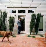 From the side door of his restored two-bedroom bungalow, Dollahite watches his dog West inspect the newly installed low-maintenance landscaping and brick patio.