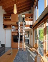A rolling ladder made from salvaged wood and components leads to a small, yet well equipped, office.