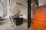 The stairs roll out into the kitchen and dining areas. The individual steps are steel trays dipped in orange liquid rubber, to squeaky effect.