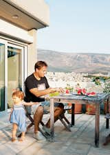Vassiliou and Angeliki tuck into watermelon slices on a patio off the master bedroom. The terrace offers views of Mount Lycabettus, whose peak towers 745 feet above Athens, and the city itself, which splays out toward the mountains in the distance.