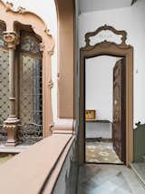The ornate facade of the Art Nouveau building carries over into the entrance. The floral pattern of the original tile floor begins in the entrance hall and continues throughout the apartment; it is offset by a sleek iron table from Minim.