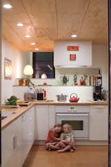 Kitchen, White, Wood, Drop In, Recessed, Cooktops, Cork, and Wall Oven Pippa (left) and Maisie (right) play in the kitchen. Though Hale and Edmonds would have preferred Bosch appliances, a deal at Ikea was too good to pass up. They purchased all of the cabinets and appliances (a combination that earned them 20-percent off the total) for a mere $4,700.  Kitchen Cooktops Recessed Wall Oven White Drop In Photos from A New Slant