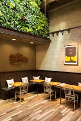 A living wall designed in collaboration with David Brenner of Habitat Horticulture introduces greenery into the cafe. "It makes you feel like you're in a courtyard," Williams says. "It helps with acoustics and plays with something soft that's not with the rest of the kit of parts." Emeco's iconic Navy chairs punctuate the interior. "We tried to select objects that are beautiful and functional," Williams says. His team looked at we looked at hundreds of chairs and were searching for a design that would work well with the overall look of the cafe but also stand out. The floor is reclaimed oak.  Search “Emecos-111-Navy-Chair.html” from Coffee Break: Peet’s Chestnut Street, San Francisco