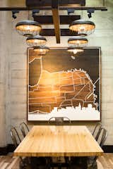 A CNC-milled map of San Francisco by artist Dave Marcoulier hangs behind a communal table. The red star denotes the cafe's location. As a local company, Peet's sought to reflect the neighborhood and orient the design to its surroundings.