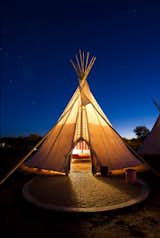 Here, one of El Cosmico's three teepees is a lantern for desert travelers.