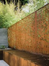 The perforations allow light and the green of the surrounding Koi bamboo to filter into the space while preserving privacy.