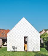 Architect Indra Janda hand-cut sheets of polycarbonate into 15¾-inch square shingles and clad the entire timber structure—a gabled roof and walls—with them.