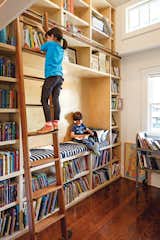 In a Boise home, a former closet was transformed into a double-height library, complete with a reading nook and a rolling ladder from Spiral Stairs of America. “That’s my favorite part of the house,” says Dan. “When I see Stella reaching for a book, there’s nothing better.” Photo by Lincoln Barbour.  Photo 2 of 8 in Dwell's 8 Favorite Playrooms by Jacqueline Leahy