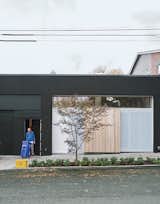 Perforated metal screens, one of which doubles as the front door, shield the storefront window from the street.