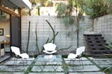Outside, a set of Bertoia chairs offer an appealing perch around a vintage glass-and-metal table.