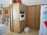 BEFORE: Prior to renovation, low-contrast wood cabinets obstructed the passage between the kitchen and the family room, giving both rooms a feeling of dullness in spite of the light tone of the wood and the walls around it.  Photo 5 of 13 in Midcentury Renovation in Austin
