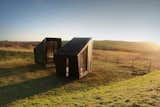 "We wanted them to be silhouettes that just exist on the landscape," says Feilden Clegg Bradley and architect Charlotte Knight, who helped design The Study and The Workshop, a pair of mobile artist's studios currently located in South Downs, two hours drive south of London. "They’re black and foreboding. In the distance, it’s quite striking."