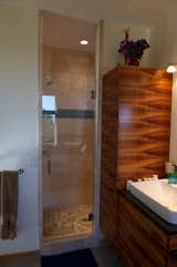 The custom koa-veneer cabinetry also found a home in the master bathroom. Photo by Barry B. Doyle.