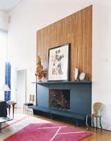In a converted church in Connecticut, a modern fireplace and mantel design incorporates a ledge that functions as a bench and place for holding artwork or extra firewood. Above the fireplace, a Warhol collage is surrounded by a papier-mâché sculpture of no special provenance, a Vigliaturo glass piece, and a Picasso plate.