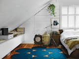 In the bedroom, a light by Bretford in Chicago is next to an Ikea Malm bed topped with Indian linens and folk weavings. The rug is from Paola Lenti. A Bocci 19 brass bowl sits near a hamper from Connected Fair Trade Goods.
