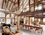 "We didn't want to diminish the openness and height and feeling of a great expanse of space," said the owner of this resurrected 19th-century barn house in Pine Plains, New York. Fortunately, the barn frame's horizontal beams perform a domestic function by creating the illusion of a lower ceiling. An abundance of furnishings in rich materials fills out the space. Photo by Raimund Koch.