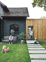 A family of cost-conscious Hamburgers converted a kitschy turn-of-the-century villa into a high-design home with a strict budget in place. To unite the quaint masonry of the original villa with the squat, ugly add-on built flush against it, the architects decided to paint the old-fashioned facade graphite gray and then covered the box next door in plain, light-colored larch. Photo by Mark Seelen.