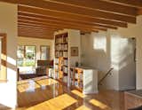 Living Room and Bookcase Quarter sawn Oak wood floors spread across the home’s shared rooms.  Photo 5 of 8 in A Midcentury Modern Renovation Opens Interiors and Admits More Sunlight by Kelly Dawson