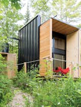 Exterior, Cabin Building Type, and Wood Siding Material A rainwater catchment system feeds a cistern and outdoor shower. The Butterfly chairs are from Hayneedle.  Search “feeds” from Camping with Dad Just Got Cooler