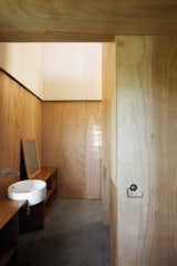 Minimalist doesn't have to mean monochromatic or marble. The Gaboon-plywood walls of the McKenzie residence in New Zealand flow through into the bathroom without a door to get in the way.
