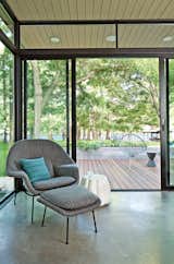In this lakeside home in Texas, a Womb Chair upholstered in Knoll fabric is accented with a Maharam pillow and a ceramic Oppiacei ottoman from Skitsch. Photo by Kimberly Davis.