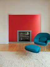 In the living room of this California home, a blue Womb chair contrasts the the bold colors of the red wall. Photo by Justin Fantl.