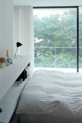 The bedroom has a view of the cherry trees.