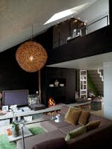 In the living room, the sofa is built in modules that can be turned to face the terrace in the summertime, or the kitchen in the winter. Photo by Per Magnus Persson.  Photo 7 of 7 in Shining Solutions for Hanging Pendants by Brandi Andres from One-Room Wonders