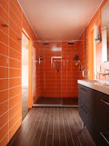 In the bathroom, Roca wall tile in Rainbow Azul continues the citrus color scheme, and the floor is clad in ceramic plank. The Ikea sinks and faucets also helped the design come in on budget.