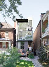 Karen White, David MacNaughtan, and their sons, Griffin and Finlay, hang out on the front deckof their narrow home in Toronto’s leafy Roncesvalles neighborhood. A narrow modernist composition of glass panes and purple brick, the house slips like a bookmark between two older buildings, a bright three-story abode on a lot narrower than most suburban driveways.  Photo by Dean Kaufman. Read more about the small house here.