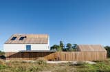 Exterior, House Building Type, and Wood Siding Material With its vertical wood slats, the garden fence helps unify the main house and the smaller shed.  Photo 3 of 8 in Modern Odes to Wood by Allie Weiss from A Modern Take on the Pitched-Roof