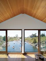 Sometimes the best way to deal with a tall, gabled ceiling is to just add windows. A line of windows in the Floating House in Lake Huron, Ontario provides a picturesque water view.  Photo by Raimund Koch.  Photo 4 of 6 in How to: Design Under a Pitched Ceiling by Allie Weiss from Floating House, Lake Huron