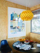 Natural wooden walls clad the dining room corner, while a marigold lantern hangs above.