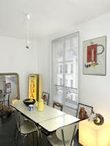 Dining Room, Table, and Chair A simple poster with bold colors adds to the industrial character of this Paris abode. Photo by Céline Clanet.  Photo 7 of 7 in How To: Decorating with Posters by Dora Vanette from Shelf Life