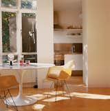 The kitchen spills out into the living room, where the focus is on a Saarinen Tulip table, Eames fiberglass shell chairs, and lamps by Achille Castiglioni.  Photo 3 of 8 in Garage Brand