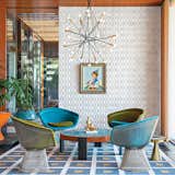 Jonathan Adler and Simon Doonan collaborated with New Haven, Connecticut, firm Gray Organschi on their midcentury-inspired New York vacation home. “There’s no right answer except to play and experiment,” Adler says about furnishing the interior. He reupholstered vintage Warren Platner chairs with velvet from Kravet. Drawings by Eva Hesse inspired the custom ceramic wall tile. Adler also created the coffee table, rug, planters, and gold stool. The pendant lamp is from Rewire in Los Angeles and the artwork is by Jean-Pierre Clément.  Photo 1 of 5 in Unique Ceramic Designs in 5 Modern Homes by Zach Edelson