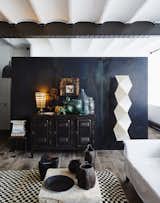 Living Room, Sofa, and Coffee Tables A vintage console and a Noguchi floor lamp sit in front of an oxidized metal partition.  Photo 3 of 5 in Editor's Letter: 5 Extraordinary Interiors We Love from Tour a 17th-Century Paris Loft Overflowing with Vintage Items