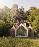 The family retreat abuts a rocky cliff in Herfell, Norway. The central cabin provides communal living spaces, while the two cabins that flank it are used as private sleeping quarters.