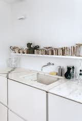 Molineus designed all of the storage units in the apartment, including the lacquered medium-density fiberboard cabinets under the kitchen sink, which is outfitted with a Vola faucet.