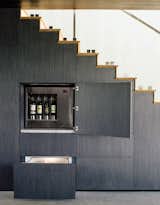 Staircase and Wood Tread The wall beneath the stairs holds hidden storage, including an Enomatic wine dispenser and Sub-Zero refrigerated drawers.  Photo 6 of 10 in A Modern Home Designed for Live Music in Beverly Hills